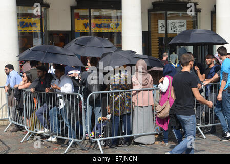 Covent Garden, London, UK. 19th September 2014. A very large queue waits in the sunshine to buy the new iPhone 6 and iPhone 6 Plus. Umbrellas are being handed out by Apple Store staff in the hot sun. Credit:  Matthew Chattle/Alamy Live News Stock Photo