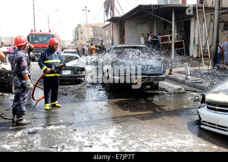 Kirkuk, Iraq. 19th Sep, 2014. Firefighters work at the site of a bomb attack in the downtown of Kirkuk, northern Iraq, on Sept. 19, 2014. A total of 17 people were killed and 55 others wounded in bomb attacks in Iraq on Friday, police sources said. Credit:  Dena Assad/Xinhua/Alamy Live News Stock Photo