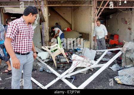 Kirkuk, Iraq. 19th Sep, 2014. People inspect the site of a bomb attack in the downtown of Kirkuk, northern Iraq, on Sept. 19, 2014. A total of 17 people were killed and 55 others wounded in bomb attacks in Iraq on Friday, police sources said. Credit:  Dena Assad/Xinhua/Alamy Live News Stock Photo