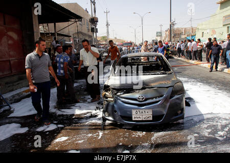 Kirkuk, Iraq. 19th Sep, 2014. People gather at the site of a bomb attack in the downtown of Kirkuk, northern Iraq, on Sept. 19, 2014. A total of 17 people were killed and 55 others wounded in bomb attacks in Iraq on Friday, police sources said. Credit:  Dena Assad/Xinhua/Alamy Live News Stock Photo