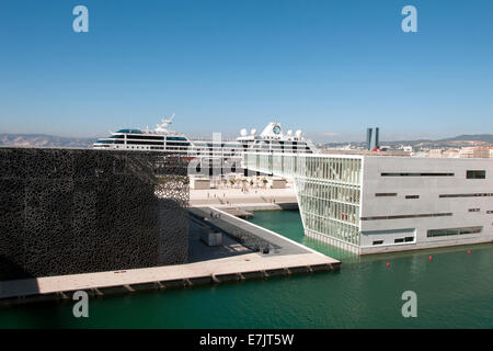 France. Marseille. Port area.  Buildings of the ultra modern MuCEM museum with an enormous cruise liner in the background. Stock Photo