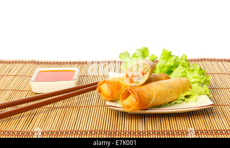 Fried spring rolls on a plate served with chili sauce against white background Stock Photo