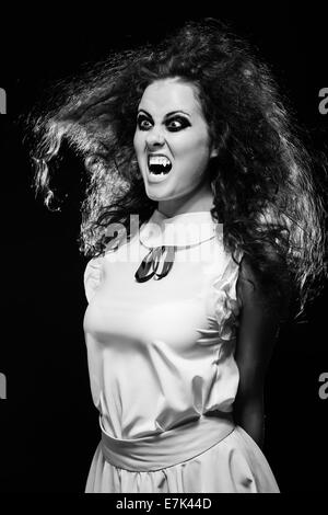 angry screaming vampire woman in dark, monochrome image Stock Photo