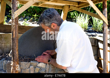 Earth cob clay oven project.  Time for the next layer of clay this time including straw for insulation. Stock Photo