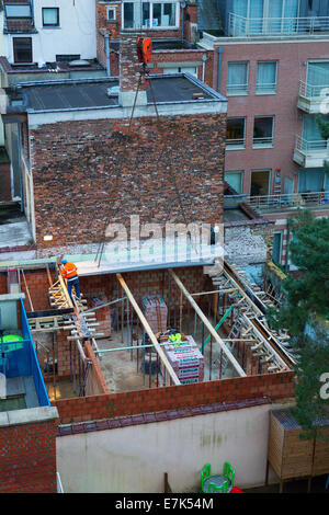 construction workers positioning precast concrete floor panels on building site Stock Photo