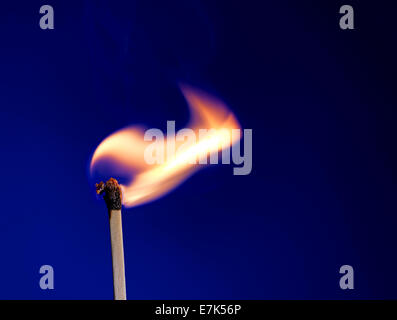 Macro shot of a flaming matchstick on blue Stock Photo