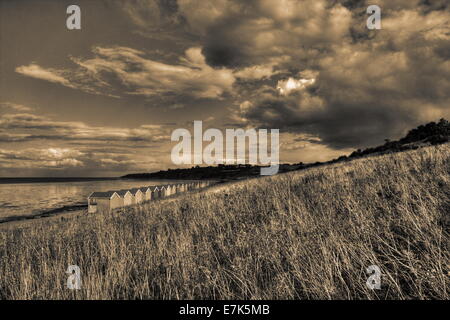 Row of beach huts as seen from the headland at Minster on Sea in Kent, England UK Stock Photo
