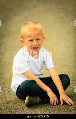 Portrait of thoughtful, pensive little boy child or kid in summer park. Stock Photo