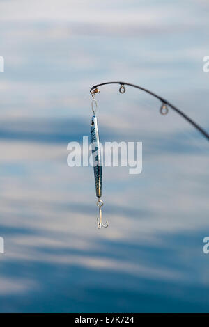 Sport and recreation. Fishing bait - rod with wobbler against the blue sea water surface Stock Photo