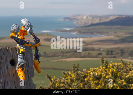 Seascape with action toy sitting on post and looking out over the gorse to the view Stock Photo