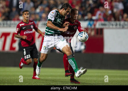 Tijuana, Mexico. 19th Sep, 2014. Dario Benedetto (R) of Xolos vies for the ball with Carlos Izquierdo of Santos in a Journey 8 match during the MX League Aperture Tournament 2014, at Caliente Stadium, in Tijuana City, northern Mexico, on Sept. 19, 2014. © Guillermo Arias/Xinhua/Alamy Live News Stock Photo