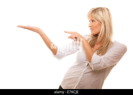 Advertisement concept - mature business woman pointing with finger showing open hand palm with blank copy space for product or t Stock Photo