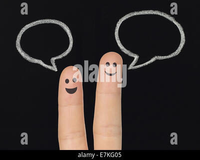 Happy fingers with chalk speech bubbles on blackboard, social media concept Stock Photo