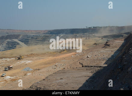 The drill and blast crew charge a blasting pattern in the foreground of a large open cast African copper mine. Stock Photo