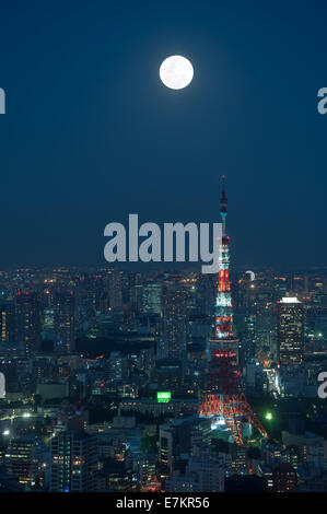 A full moon hangs over the Tokyo cityscape at night. Stock Photo