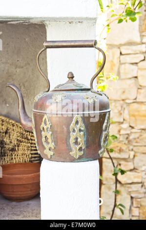 An old copper kettle on a white wall Stock Photo
