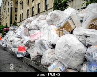 https://l450v.alamy.com/450v/e7m3hg/plastic-bags-of-trash-ready-for-pickup-are-stacked-on-the-sidewalk-e7m3hg.jpg