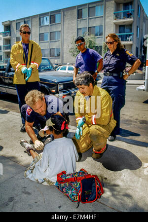 San Diego Fire Department paramedics aid an African American injured child after an automobile accident in the City Heights neighborhood. Stock Photo