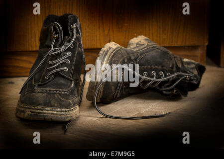 A pair of dirty boots on wooden floor Stock Photo