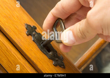 The man hand, locking a key from a wood door Stock Photo