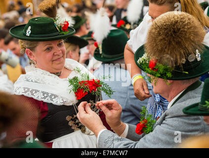 Munich, Germany. 21st Sep, 2014. Two persons wearing traditional costumes stand in the 'Oide Wiesn' festival tent after the costume and shooting club parade at the Oktoberfest in Munich (Bavaria), Germany, 21 September 2014. The annual beer festival runs from 20 September to 05 October. Photo: Marc Mueller/dpa Credit:  dpa picture alliance/Alamy Live News Stock Photo