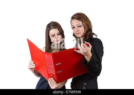 Two women reading from a red folder. Stock Photo