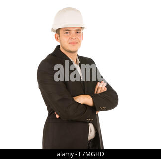 Confident Young Engineer with Crossed Arms in Black Coat and White Helmet. Looking at Camera. Stock Photo