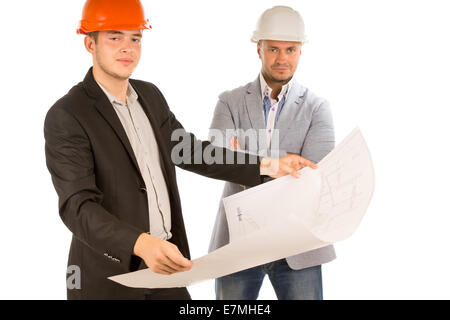 Two architects or structural engineers standing looking at a building plan or blueprint which one of them is holding watched by  Stock Photo