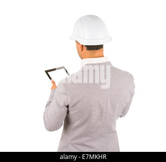View from behind of an architect in a hardhat standing using a tablet computer, isolated on white Stock Photo