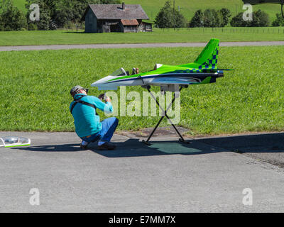 Model aircraft enthusiast repairing the nose wheel of his jet aircraft which was damaged on landing Stock Photo