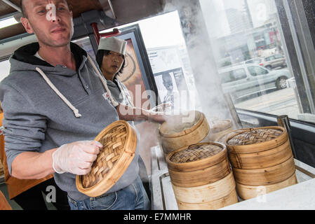 Warsaw, Poland. 21th September, 2014. Men prepares momo dumplings steamed in bamboo baskets during food trucks festival in front of Palace of Culture and Science in Warsaw. Credit:  kpzfoto/Ģ����ý Live News Stock Photo