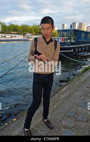paris, France, Young Chinese Man, Tourist, Portrait, Using Iphone Smart Phone Telephone, Outside on Seine River,  PORTRAIT OF GUY ON STREET people Stock Photo