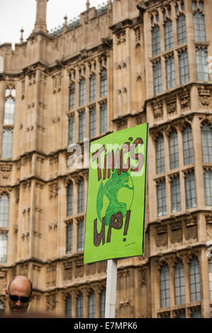 A demonstrator holds a placard which says 'Time's Up!' as he marches in front of the Houses of Parliament during the Climate Change demonstration, London, 21st September 2014. © Sue Cunningham Stock Photo