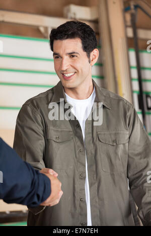 Young Carpenter Shaking Hands With Colleague Stock Photo