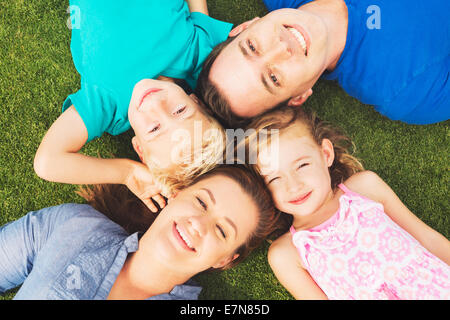 Portrait of Happy Family of Four Outside On the Grass Stock Photo