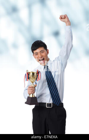 Businessman holding trophy Stock Photo