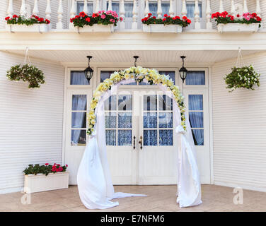 Wedding archway with flowers arranged for a wedding ceremony Stock Photo