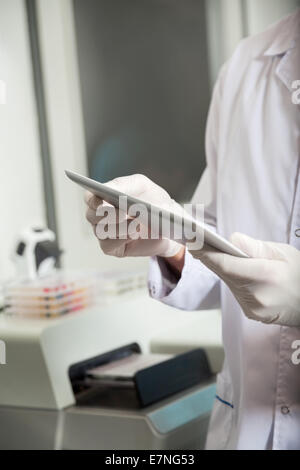 Technician Using Digital Tablet In Medical Lab Stock Photo