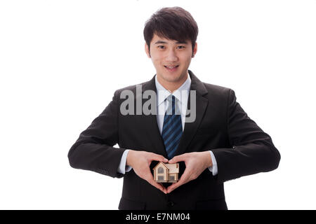 Businessman holding house model Stock Photo
