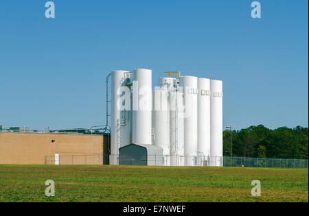 A set of industrial silos attached to a light industrial food processing facility. Stock Photo