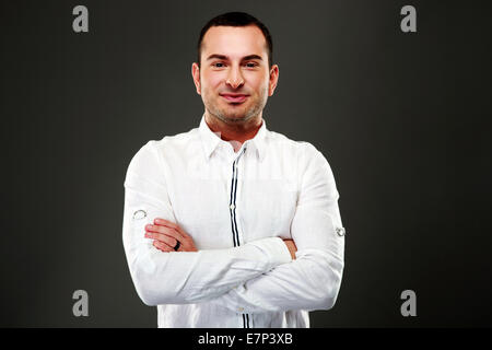 Portrait of smiling businessman standing with arms folded Stock Photo