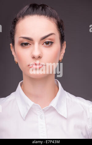 Serious woman wearing white blouse Stock Photo