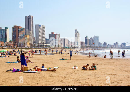 Many unknown people enjoy early morning sunshine against city sky line in Durban, South Africa Stock Photo