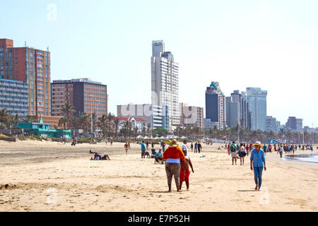 Many unknown people enjoy early morning sunshine against city sky line in Durban, South Africa Stock Photo