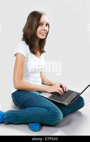 Girl with Laptop computer isolated on gray background Stock Photo