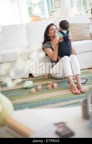 Mother playing with her son (6-11 months) in living room Stock Photo