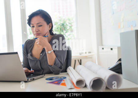 Female architect working with laptop Stock Photo