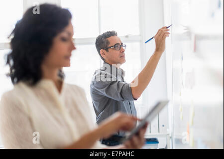 Men and woman with camping accessories standing in field Stock