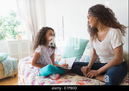 Girl (8-9) using digital tablet on bed Stock Photo