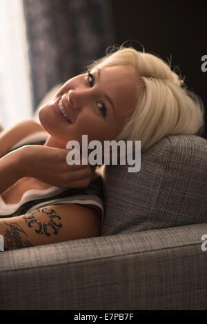 Portrait of blonde woman relaxing on sofa Stock Photo